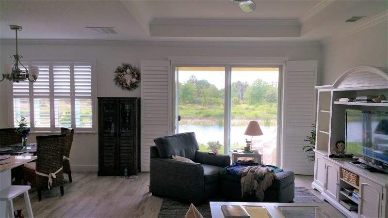 Norman bifold shutter doors on slider open and matching shutters in window