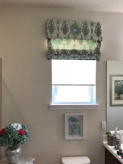 Valance and fabric roman shade in bathroom window
